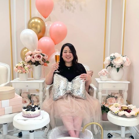 Kim celebrating in a pedicure chair with balloons, flowers and a birthday cake